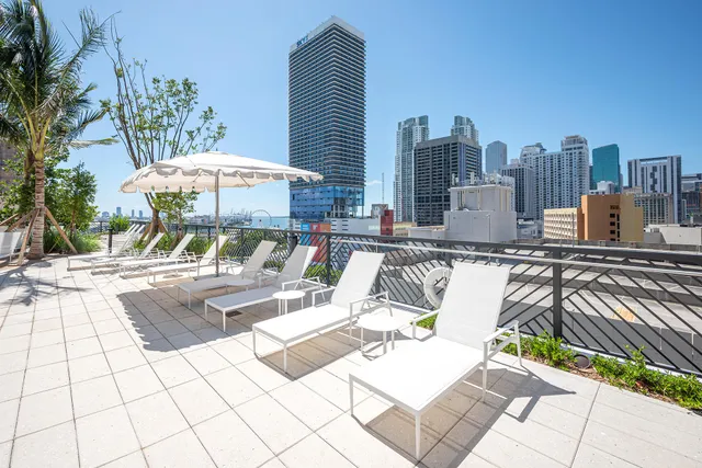 a patio with a table and chairs and a barbeque