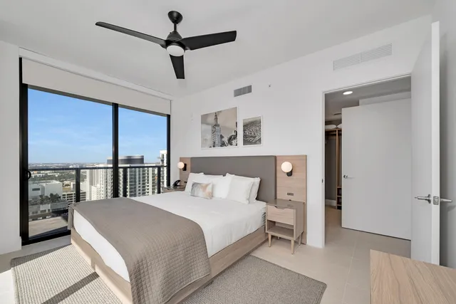 a bedroom with a large bed and a flat tv screen on dresser