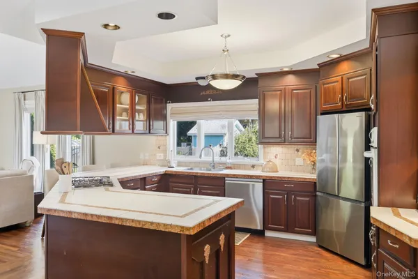 a kitchen with a sink a refrigerator and wooden cabinets