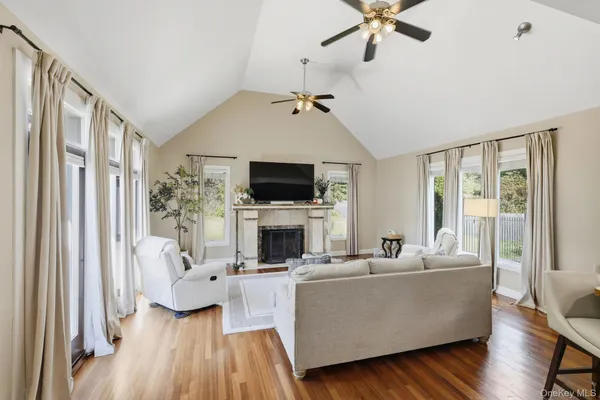 a living room with furniture a fireplace and a flat screen tv