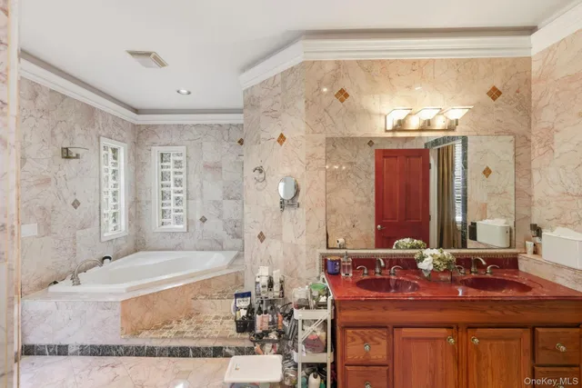 a bathroom with a granite countertop tub sink shower and mirror
