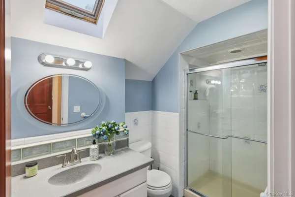 a bathroom with a sink a toilet and a mirror