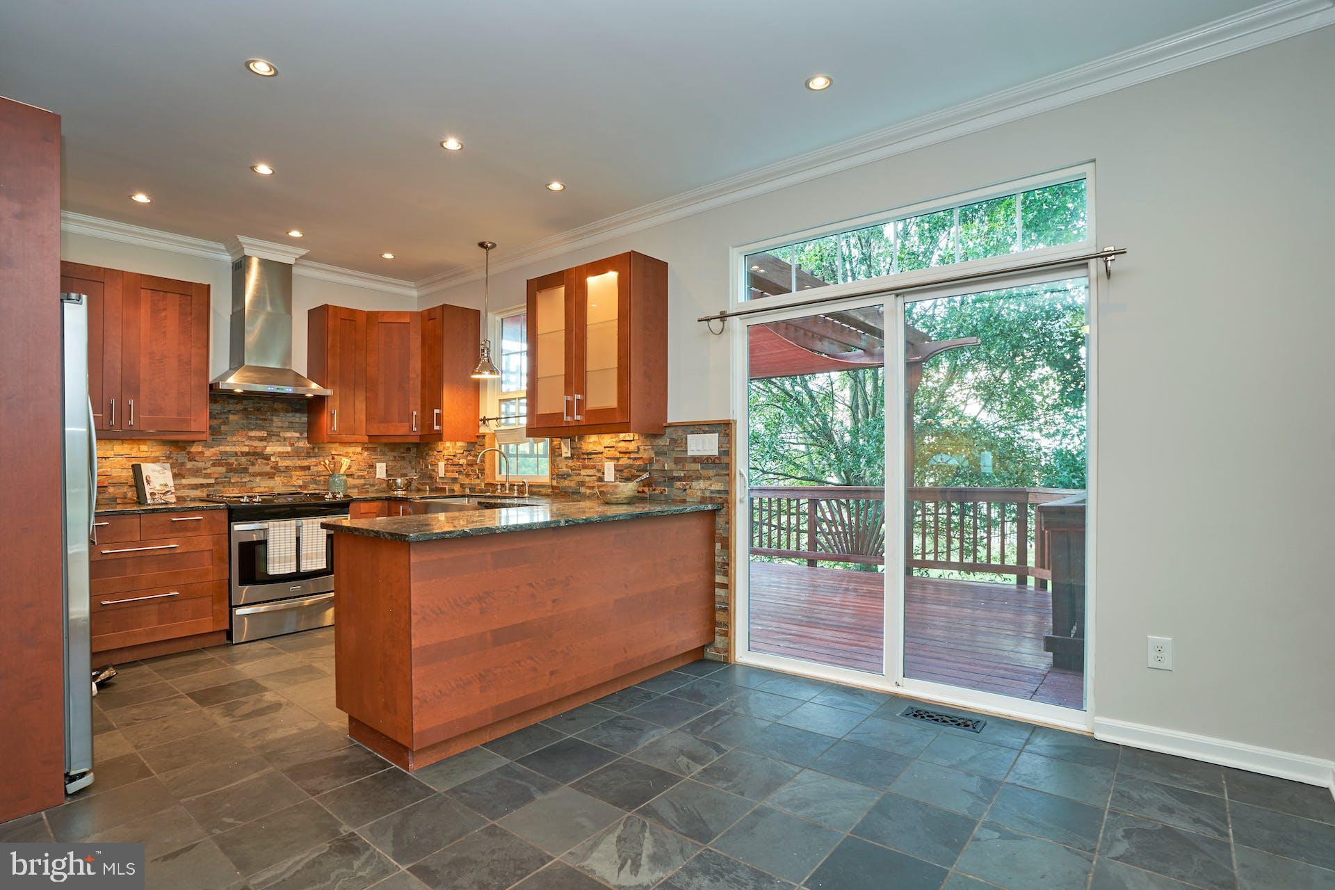21822 Kings Crossing Terrace Ashburn, VA 20147 - Photo 1 of 39 a kitchen with kitchen island granite countertop a stove a sink and a refrigerator