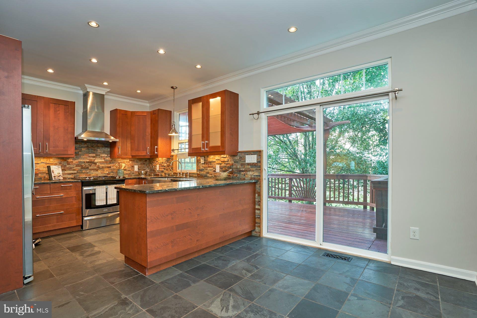 a kitchen with kitchen island granite countertop a stove a sink and a refrigerator