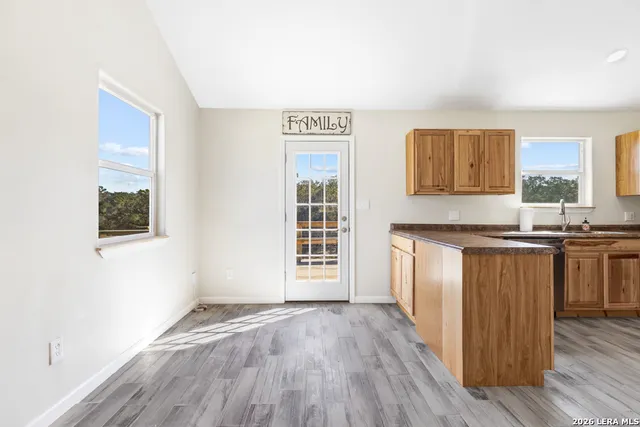 a view of kitchen with granite countertop window and wooden floor