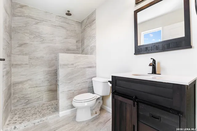 a bathroom with a toilet a sink and mirror