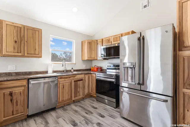 a kitchen with stainless steel appliances granite countertop a refrigerator stove and microwave