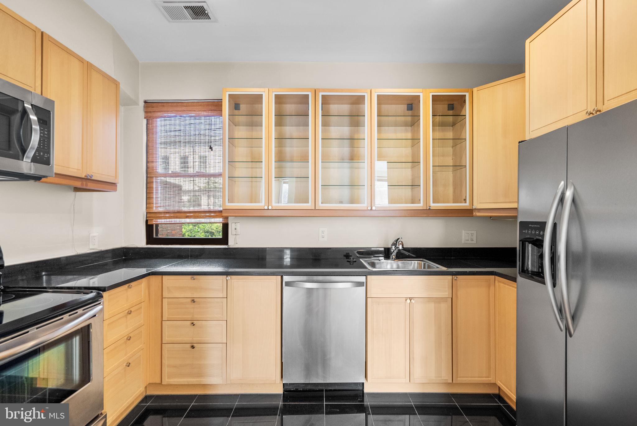 1318 35th Street Northwest, Unit 7 Washington, DC 20007 - Photo 12 of 27 a kitchen with granite countertop a sink a stove and refrigerator