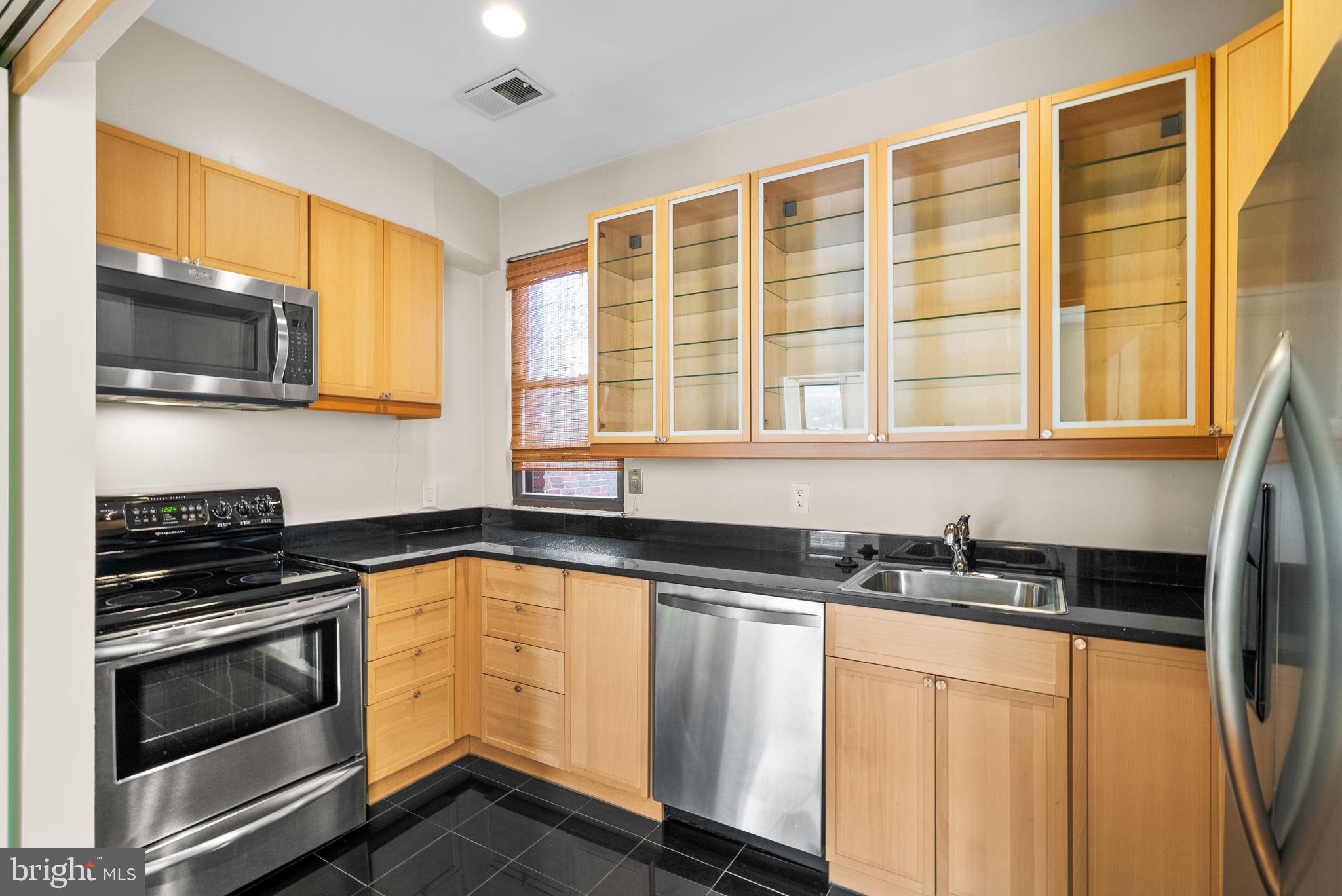1318 35th Street Northwest, Unit 7 Washington, DC 20007 - Photo 13 of 27 a kitchen with granite countertop a stove sink and microwave
