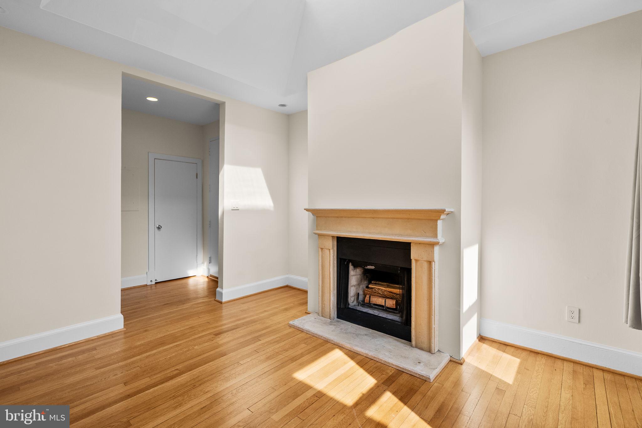 1318 35th Street Northwest, Unit 7 Washington, DC 20007 - Photo 9 of 27 a view of an empty room with wooden floor and a fireplace