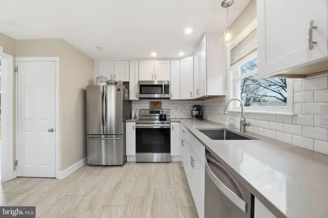 a kitchen with stainless steel appliances granite countertop a refrigerator stove and sink