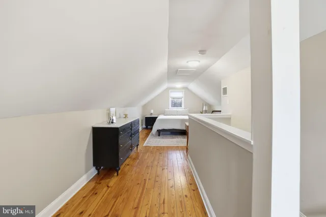 a view of a kitchen with kitchen island a sink wooden floor and stainless steel appliances
