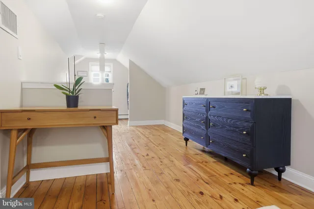 a room with a dresser and a potted plant