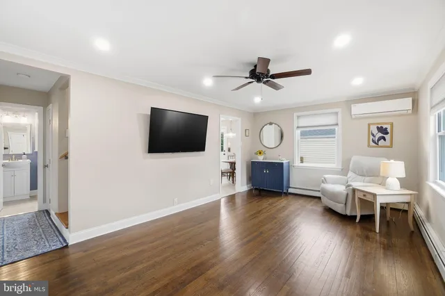 a living room with furniture wooden floor and a flat screen tv