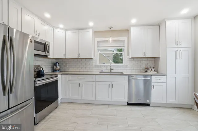 a kitchen with stainless steel appliances granite countertop a refrigerator sink and stove
