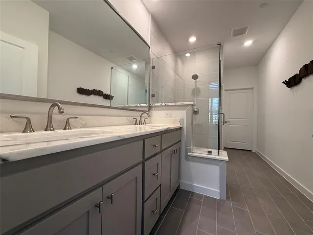 a bathroom with a double vanity sink a mirror and a shower