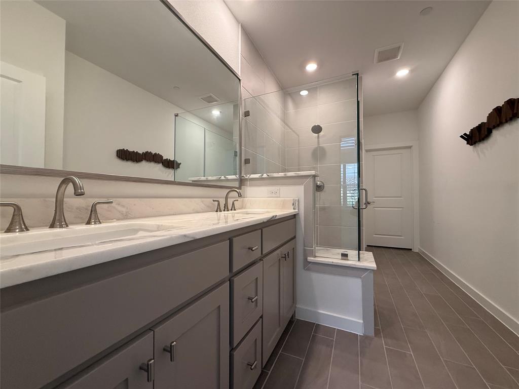 2805 Concord Drive Wylie, TX 75098 - Photo 13 of 19 a bathroom with a double vanity sink a mirror and a shower