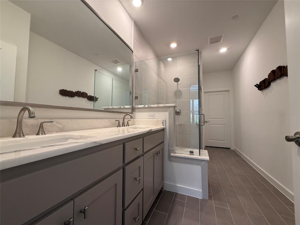 2805 Concord Drive Wylie, TX 75098 - Photo 15 of 19 a bathroom with a double vanity sink a mirror and a shower