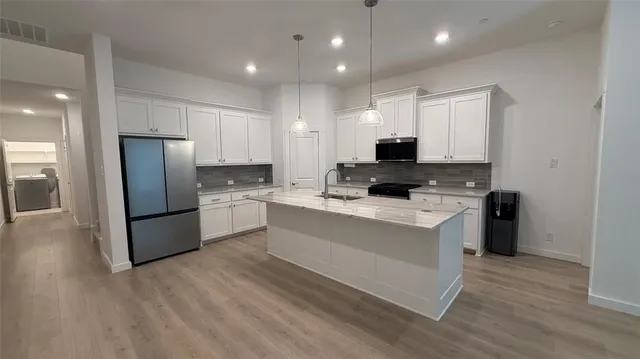 a kitchen with a refrigerator a stove top oven a sink and a center island