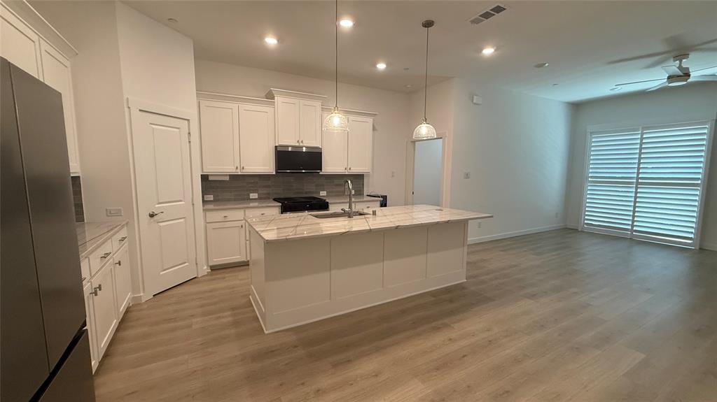 2805 Concord Drive Wylie, TX 75098 - Photo 4 of 19 a large white kitchen with kitchen island a sink stainless steel appliances and cabinets