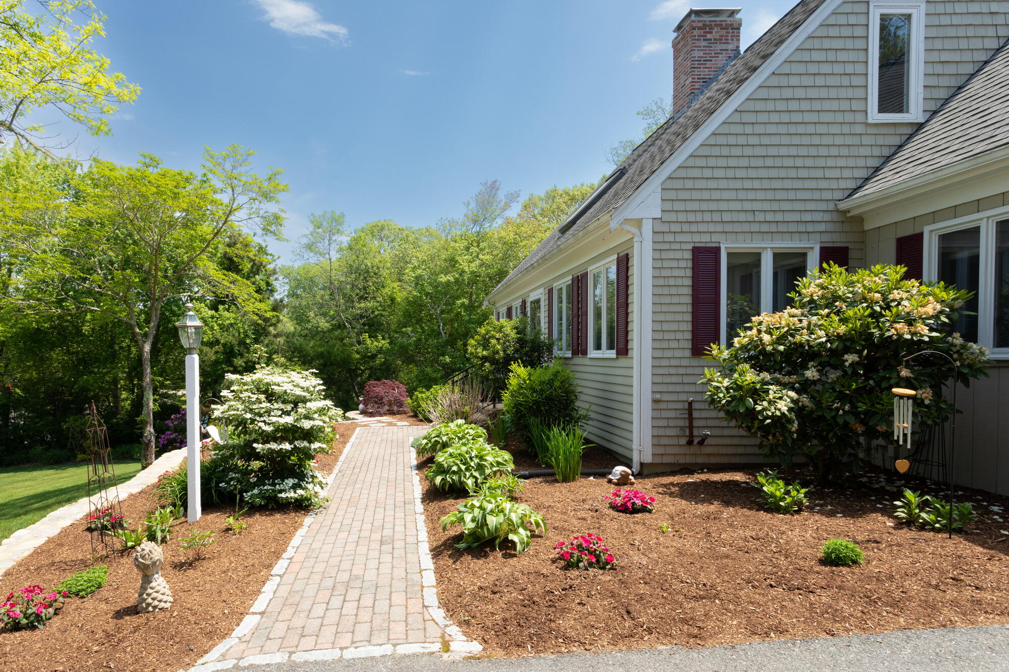 21 Captain Isiah's Road Cotuit, MA 02635 - Photo 7 of 47 a backyard of a house with wooden fence and plants