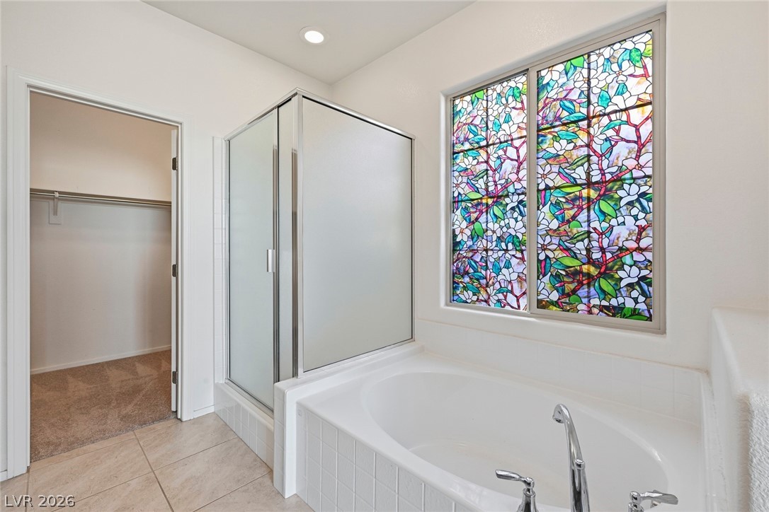 250 Dedication Avenue Henderson, NV 89011 - Photo 25 of 67 Full bathroom featuring a walk in closet, a shower stall, a garden tub, light tile patterned floors, and recessed lighting