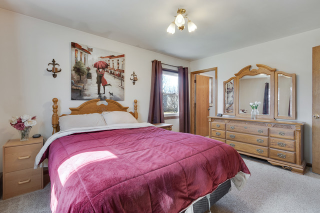 5001 Tile Line Road Crystal Lake, IL 60012 - Photo 17 of 30 a bedroom with a bed and a chandelier