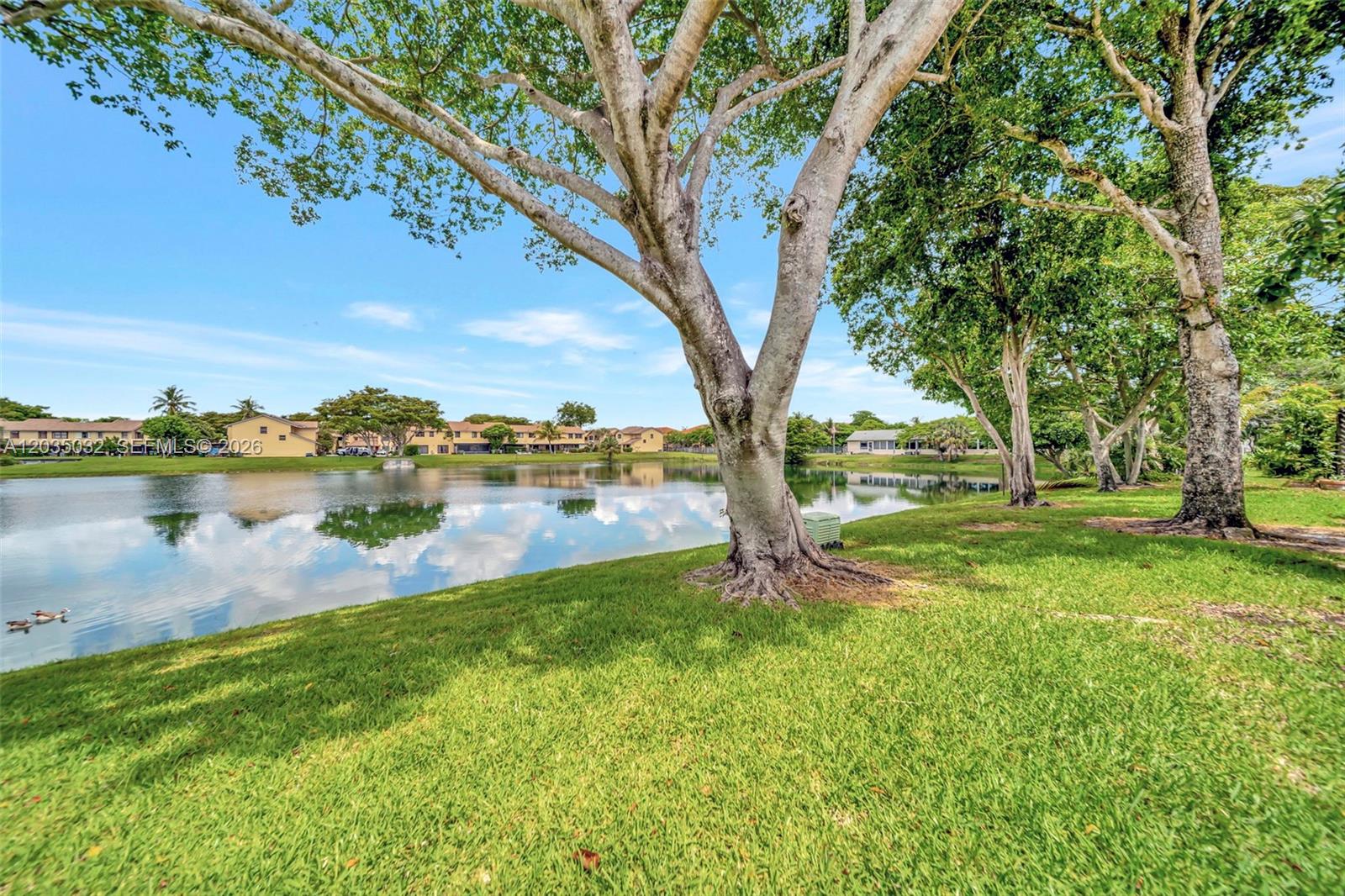 5223 Gate Lake Road, Unit 5223 Tamarac, FL 33319 - Photo 35 of 37 a view of a lake with houses in front of big yard