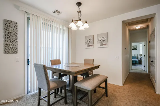 a view of a dining room with furniture and chandelier