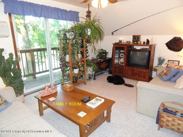 512 Myo Beach Road Meshoppen, PA 18630 - Photo 7 of 17 a living room with furniture a flat screen tv and a floor to ceiling window