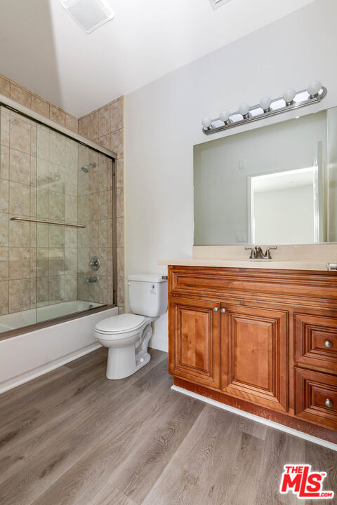14735 Friar Street, Unit 104 Van Nuys, CA 91411 - Photo 12 of 16 a bathroom with a granite countertop toilet a sink and mirror