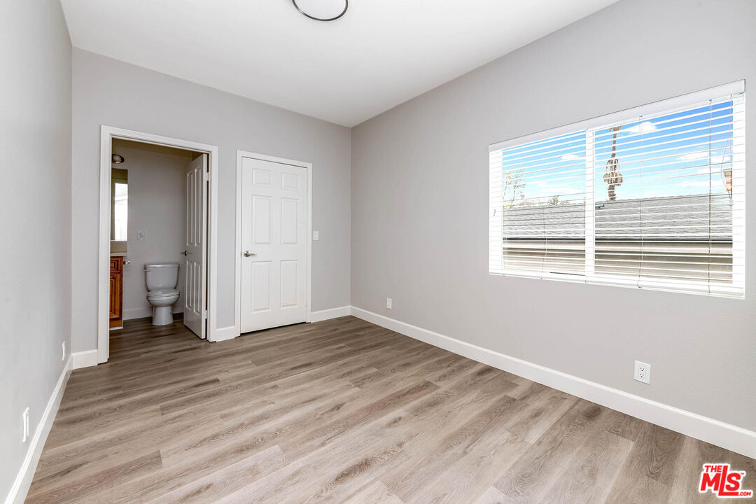 14735 Friar Street, Unit 104 Van Nuys, CA 91411 - Photo 15 of 16 a view of an empty room with wooden floor and a window