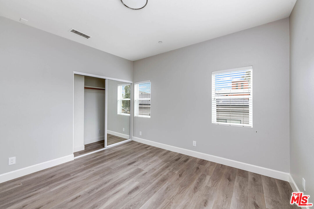 14735 Friar Street, Unit 104 Van Nuys, CA 91411 - Photo 10 of 16 a view of an empty room with wooden floor and a window