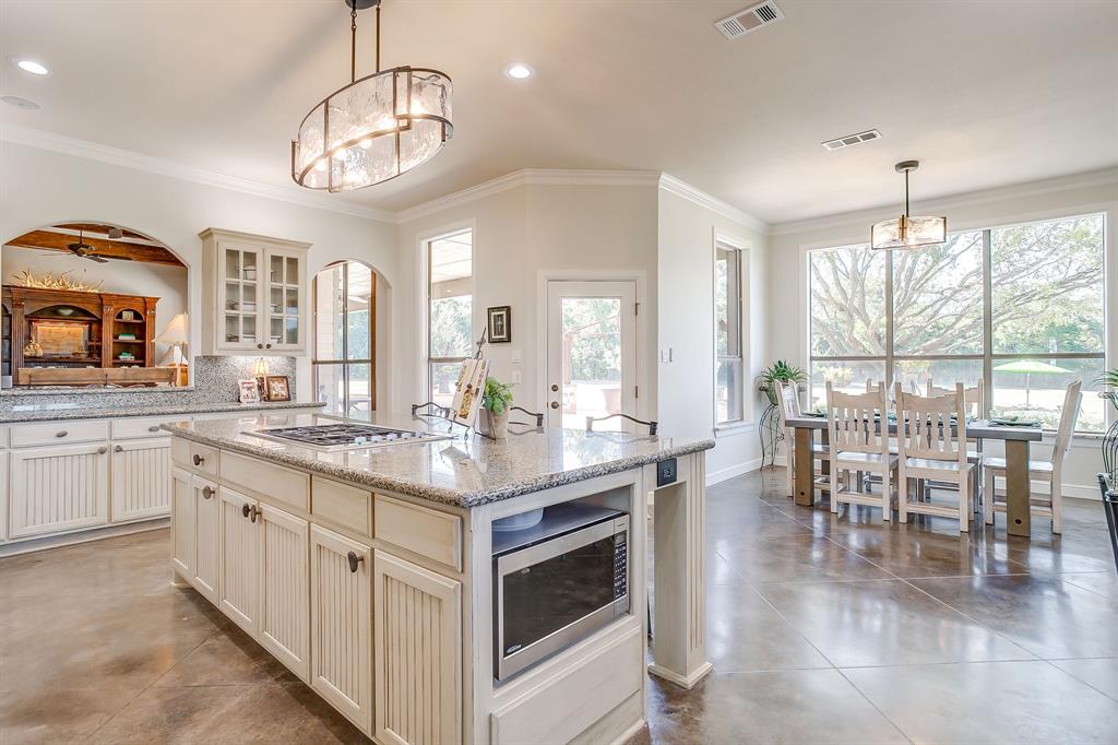 4991 Old Millsap Road Millsap, TX 76066 - Photo 14 of 40 a kitchen with center island table and chairs in it