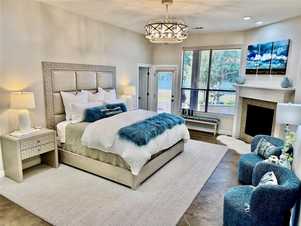 4991 Old Millsap Road Millsap, TX 76066 - Photo 18 of 40 a spacious bedroom with a bed couches chair fireplace and a flat tv screen