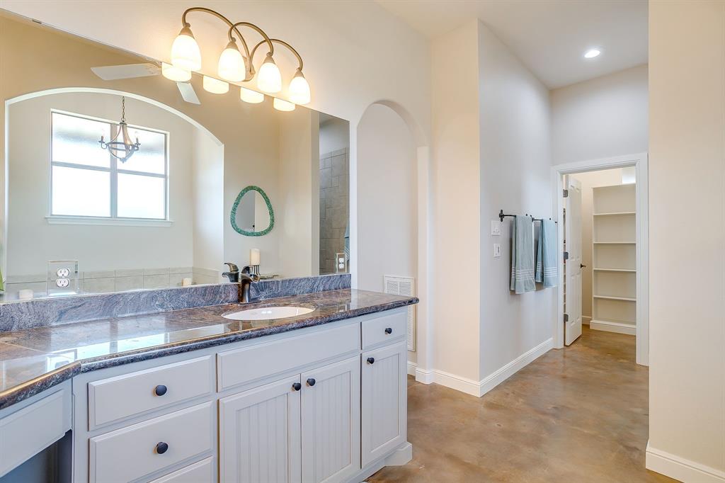 4991 Old Millsap Road Millsap, TX 76066 - Photo 20 of 40 a bathroom with a granite countertop sink a large mirror and a window