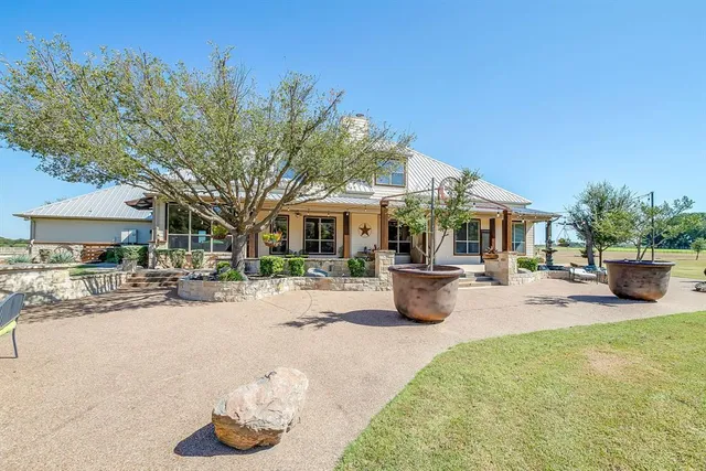 a view of a house with backyard and sitting area