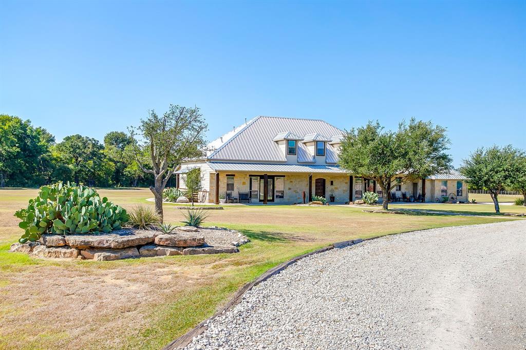 4991 Old Millsap Road Millsap, TX 76066 - Photo 3 of 40 a front view of a house with a garden and patio