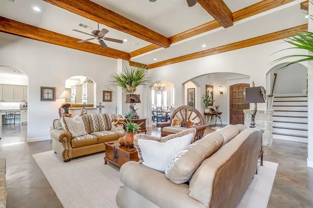 a living room with furniture flowers and a chandelier