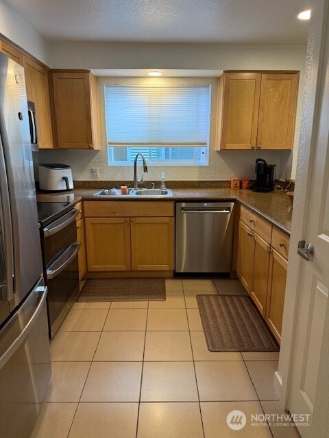 1311 12th Avenue South, Unit D301 Seattle, WA 98144 - Photo 8 of 12 a kitchen with stainless steel appliances granite countertop a sink stove and refrigerator