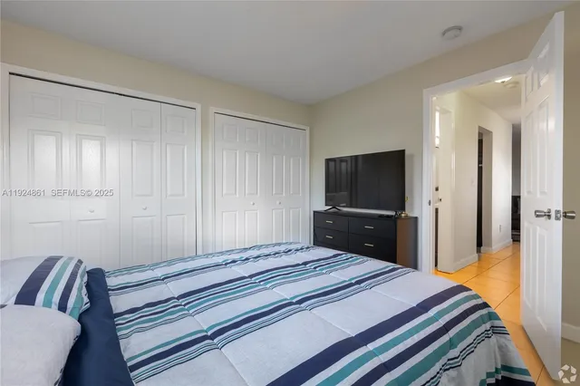 a bedroom with a bed and a flat screen tv