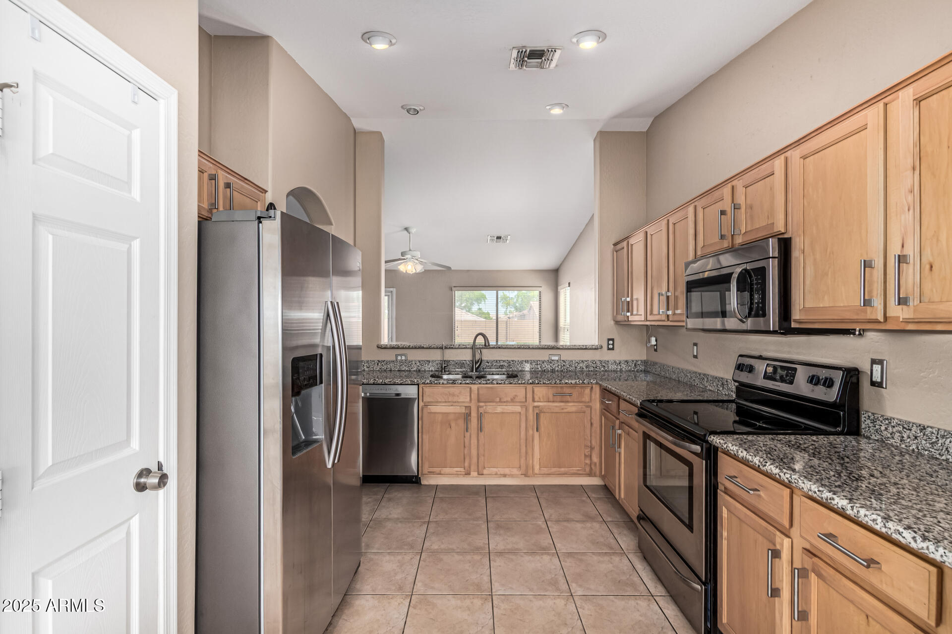 1634 East Harwell Road Phoenix, AZ 85042 - Photo 10 of 44 a large kitchen with stainless steel appliances granite countertop a stove top oven a refrigerator and a sink
