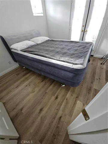 a bedroom with a bed and wooden floor