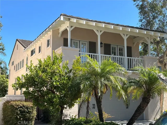 a view of a white house with a large windows and flower plants