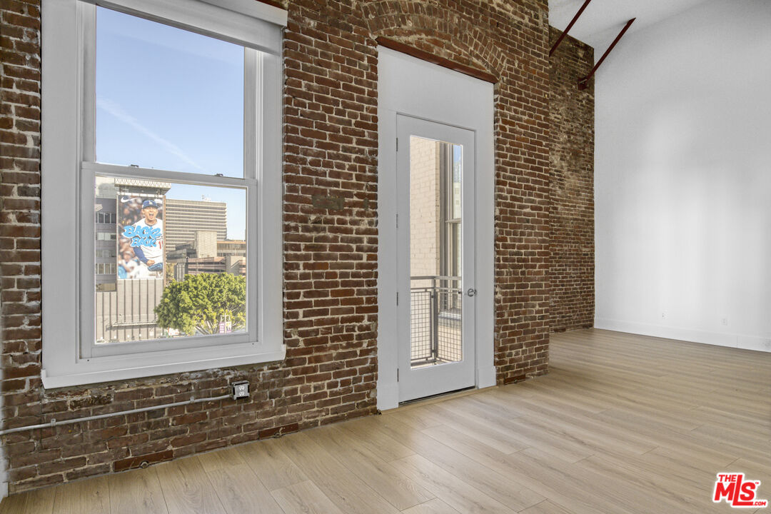 253 South Broadway, Unit 507 Los Angeles, CA 90012 - Photo 16 of 33 an empty room with wooden floor and windows