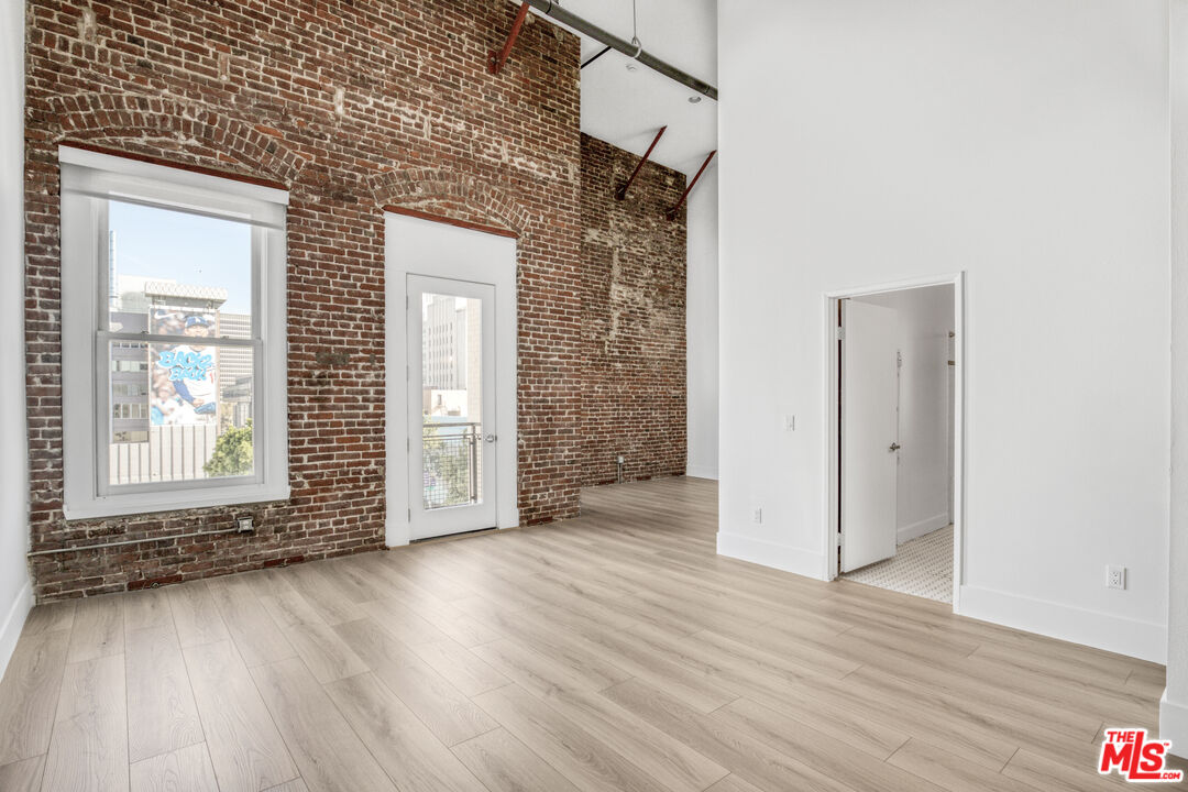 253 South Broadway, Unit 507 Los Angeles, CA 90012 - Photo 6 of 33 an empty room with wooden floor and windows