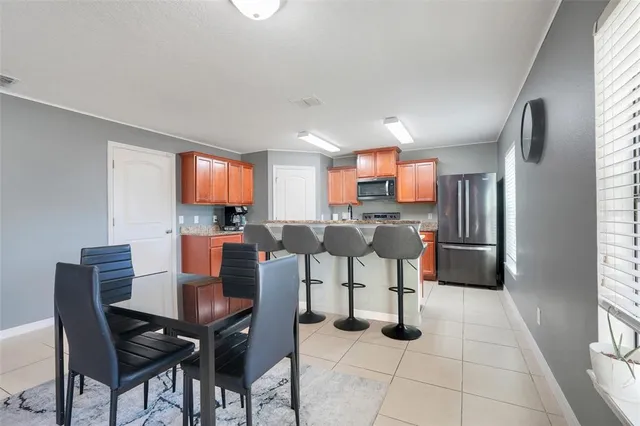 a open kitchen with stainless steel appliances kitchen island granite countertop a table and chairs