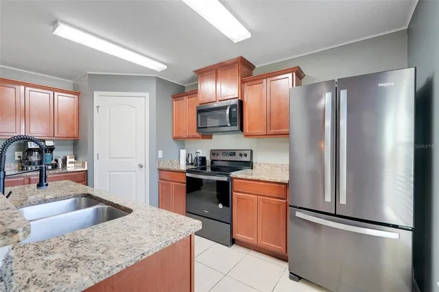a kitchen with stainless steel appliances granite countertop a refrigerator stove and sink
