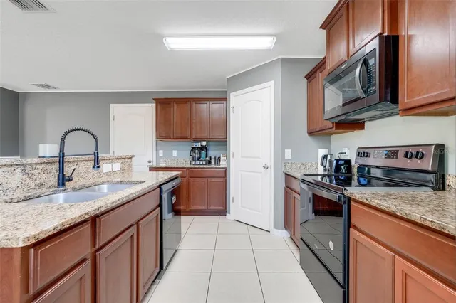 a kitchen with stainless steel appliances granite countertop a sink stove and cabinets