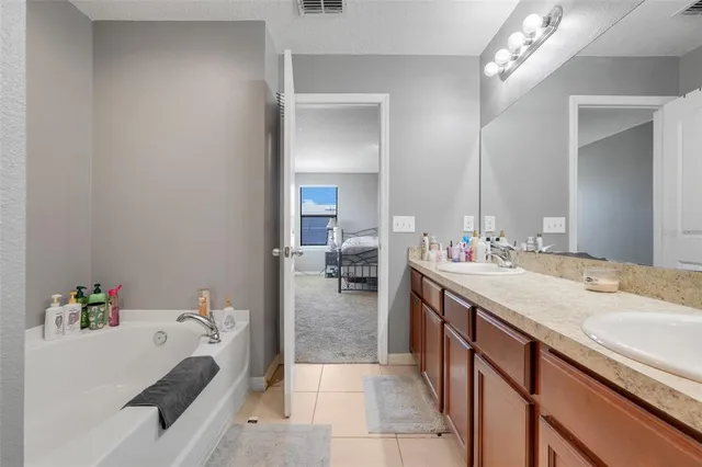 a en suite bathroom with a granite countertop sink and a mirror